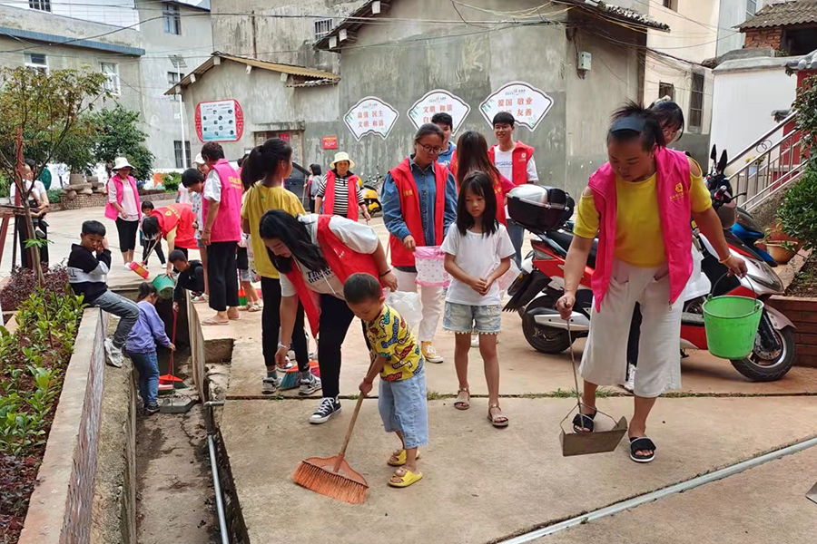 巾幗志愿者帶上孩子一起帶頭打掃衛(wèi)生，美化綠化庭院及巷道。（江川區(qū)婦聯(lián)供圖）.jpg