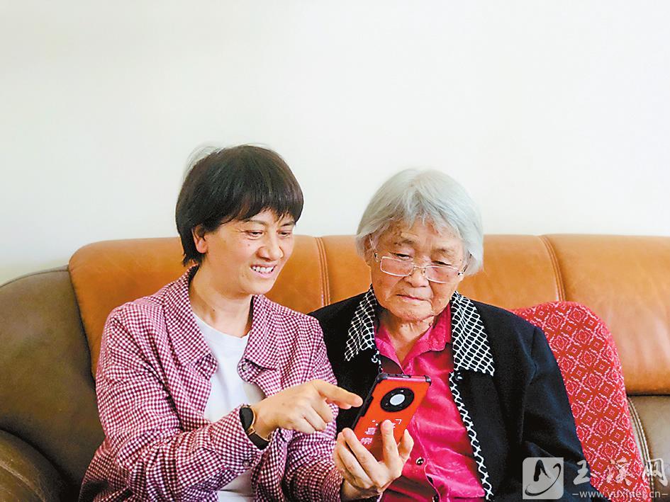 丁樹芬正在給90歲的老同志聶淑芬演示如何使用“學(xué)習(xí)強國”App。 （圖片由丁樹芬提供）