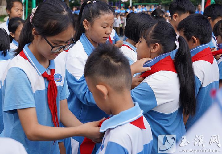 為新隊(duì)員佩戴紅領(lǐng)巾。